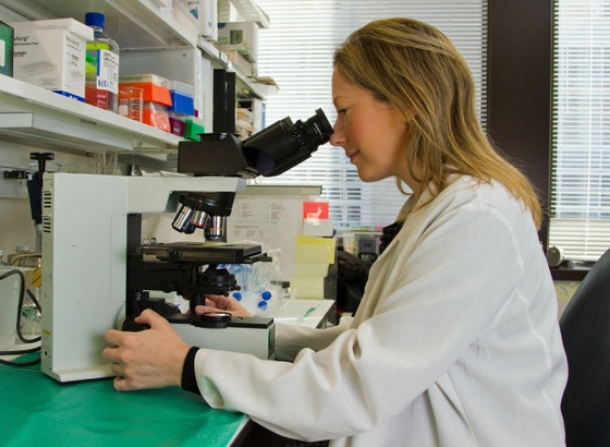 A woman wearing a white coat, exuding professionalism and elegance.